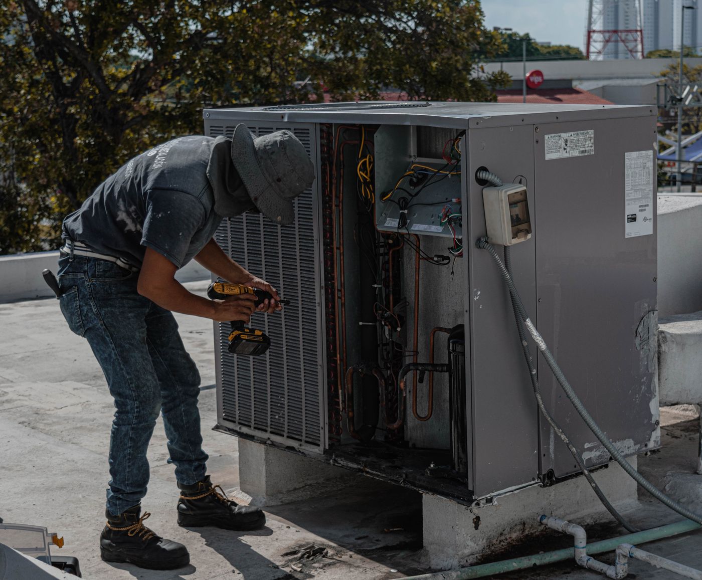 HVAC technician repairing an outdoor air-conditioning unit